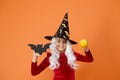 On Halloween night youre sure to have fright. Halloween girl in witch hat orange background. Little girl hold Halloween Royalty Free Stock Photo