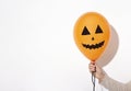 Halloween orange balloon with smiling face in woman hand Royalty Free Stock Photo