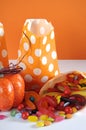 Halloween orange polka dot trick or treat paper bags with multi-color candy - vertical.