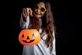 Halloween orange pumpkin in hand of beautiful attractive black long hair woman in spooky white ghost costume Royalty Free Stock Photo