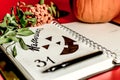 Halloween. orange pumpkin writing pad with painted black Jack. dry foliage dry berries with empty space