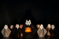 The Halloween origami or Paper folding Nun holding pumpkin head jack-o-lantern made from folded paper with many nuns at the