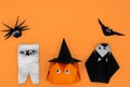 The Halloween origami or Paper folding of pumpkin head jack-o-lantern, mummy, nun, spider and bat on orange background Royalty Free Stock Photo