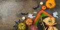 Halloween party banner concept with plate, pumpkin and decorations on dark background. Top view, flat lay