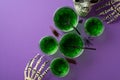 Halloween party concept. Top view photo of green drink with floating spiders in glasses skull skeleton hands creepy insects