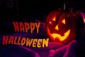 Halloween party and fall holidays concept with lit jack o`lantern pumpkin with scary glowing eyes and creepy smile lighting the
