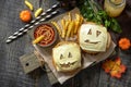 Halloween party food. Halloween party fun ghost burger, ketup sauce and potatoes frie on a wooden table. Top view.