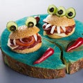 Halloween party food. Monster hamburgers close up with red chili peppers. Royalty Free Stock Photo