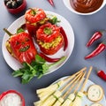 Halloween party food. Red stuffed peppers with scary cutout faces, witches brooms of cheese and other treats Royalty Free Stock Photo