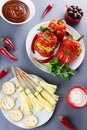 Halloween party food. Red stuffed peppers with scary cutout faces, witches brooms of cheese and other treats Royalty Free Stock Photo