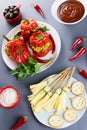 Halloween party food. Red stuffed peppers with scary cutout faces, witches brooms of cheese and other treats Royalty Free Stock Photo