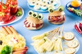 Halloween party food. Stuffed peppers with scary faces, cheese witches brooms, monster hamburgers, witch finger treats. Royalty Free Stock Photo