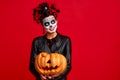 Halloween Party girl. Happy girl with sugar skull makeup, with a wreath of flowers on her head and skull, wearth lace gloves and