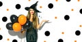 Halloween party girl. witch holding black and orange air balloons