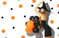 Halloween party girl. witch holding black and orange air balloons