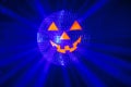 Halloween party pumpkin disco ball, jack o`lantern with shiny rays in smoke