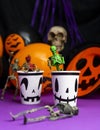 Halloween party. Skeletons coming out from the cup with balloons and skull in the background Royalty Free Stock Photo