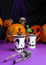 Halloween party. Skeletons coming out from the cup with balloons and skull in the background Royalty Free Stock Photo