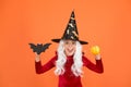 Halloween party. Small girl in black witch hat. Autumn holiday. Join celebration. Halloween attributes. Little child in Royalty Free Stock Photo