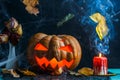 Halloween photo of table with pumpkin, burning candle, cobweb