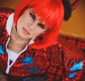 Halloween. Portrait of a beautiful girl in a red wig with horns closeup. Red, festive makeup. Royalty Free Stock Photo