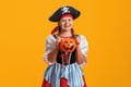 Halloween. Portrait of a child in a carnival costume of a pirate in the studio on a yellow background. Royalty Free Stock Photo