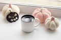 Halloween preparation. Craft halloween decorative handmade pumpkins and up of hot coffee americano on the window sill.