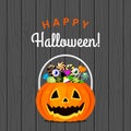 Halloween pumpkin bucket with candies different sweets on a wooden background. Royalty Free Stock Photo