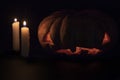 Halloween pumpkin and candle on dark background. Halloween eve banner template. Carved pumpkin with creepy face.