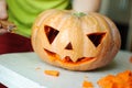 Halloween pumpkin cutting process, process of making Jack-o-lantern. Male hands with knife.