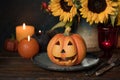 Halloween pumpkin decor with candle and flowers