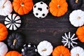 Halloween pumpkin decor frame. Orange, black and white patterns against a black wood banner background. Copy space. Royalty Free Stock Photo