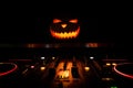 Halloween pumpkin on a dj table with headphones on dark background with copy space. Happy Halloween festival decorations and music