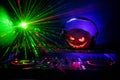 Halloween pumpkin on a dj table with headphones on dark background with copy space. Happy Halloween festival decorations and music Royalty Free Stock Photo