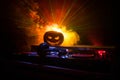 Halloween pumpkin on a dj table with headphones on dark background with copy space. Happy Halloween festival decorations and music Royalty Free Stock Photo