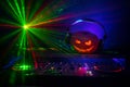 Halloween pumpkin on a dj table with headphones on dark background with copy space. Happy Halloween festival decorations and music Royalty Free Stock Photo