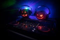 Halloween pumpkin on a dj table with headphones on dark background with copy space. Happy Halloween festival decorations and music Royalty Free Stock Photo