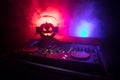 Halloween pumpkin on a dj table with headphones on dark background with copy space. Happy Halloween festival decorations and music Royalty Free Stock Photo