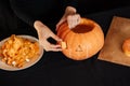 Halloween pumpkin. Girl hands prepares traditional decoration for the celebration