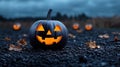 Halloween pumpkin with glowing face surrounded by scattered leaves Royalty Free Stock Photo