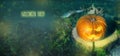 Halloween pumpkin on the ground at night in a mystical forest. Halloween background. Sinister eyes of pumpkins. Halloween party. Royalty Free Stock Photo