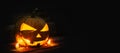 Halloween pumpkin head jack lantern with burning candles on dark moody background Royalty Free Stock Photo