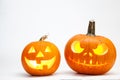 Two Halloween pumpkin head jack lantern with burning candles isolated on white background