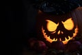 Halloween pumpkin head jack lantern with luminous eyes and mouth with candlelight on black background Royalty Free Stock Photo