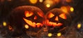 Halloween pumpkin head jack o lantern with burning fire and smoke background, wooden table with light bokeh garland. Beautiful Royalty Free Stock Photo