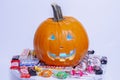 A halloween pumpkin jack-o-lantern with popular halloween candies brands on a white