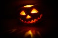 Halloween pumpkin lantern jack glowing in the dark. Reflection of light on surface. Royalty Free Stock Photo