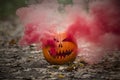 Halloween pumpkin lantern with smoking eyes and light mouth