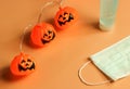 Halloween pumpkin lights, medical mask and alcohol sanitizer gel on orange background. Halloween , COVID-19 prevention and new Royalty Free Stock Photo