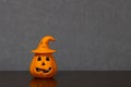 Halloween pumpkin ornament with witch hat placed off-center on shelf